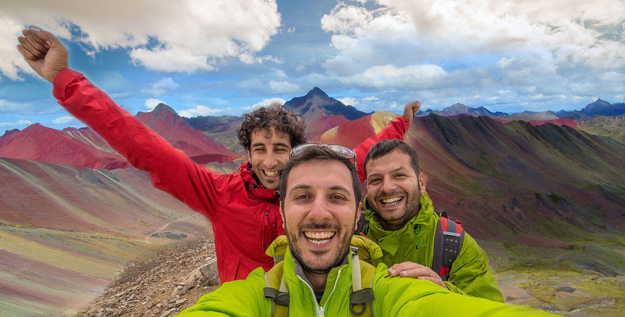happy hikers at rainbow mountain summit
