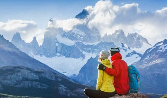 couple-cuddling-on-mountain-top-enjoying-views