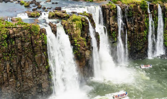 Rushing Iguazu Falls with boats below