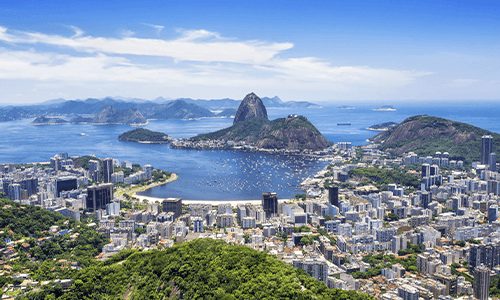 Birds eye view of Rio de Janiero, featuring the city, beach, and Sugarloaf Mountain
