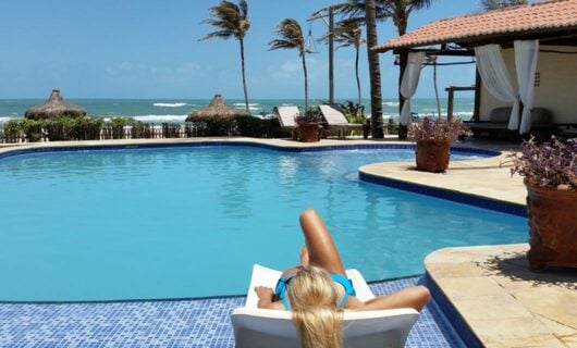woman lounging by resort pool Fortaleza