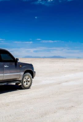 SUV drives across salt flats of Bolivia