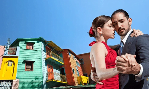 A pair dancing the Tango the colorful houses of Buenos Aires La Boca in the background