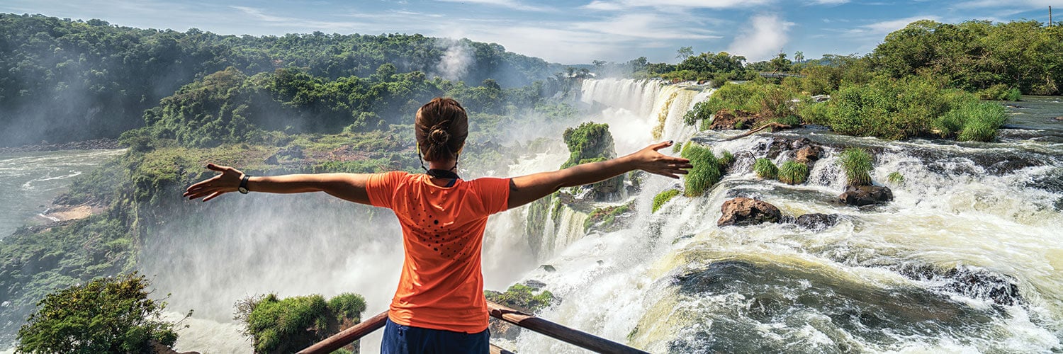woman visiting iguazu falls brazil in the summer