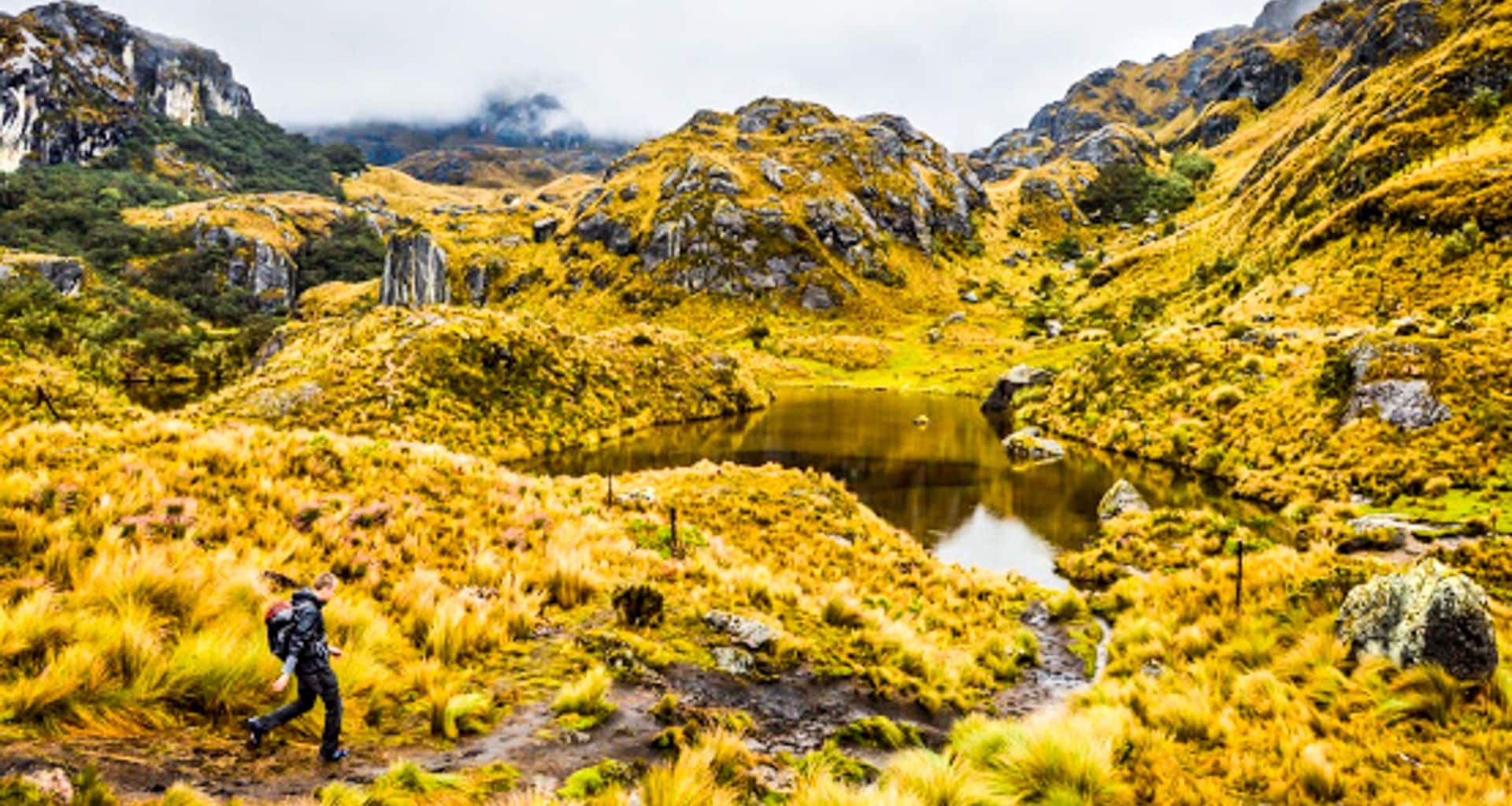 Hiker passes mountain pond