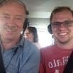 Two men wearing headsets smile at the camera while sitting in the front seats of a small aircraft—just another adventure with SouthAmerica.travel. A woman is visible in the back seat between them, ready for more travel recommendations.