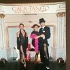Three people dressed in elegant tango attire pose before a Gala Tango backdrop, echoing the spirit of Argentina. Two women in black dresses and a man in a suit and hat evoke the timeless allure of Evita.
