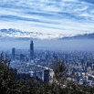 A cityscape with tall buildings under a blue, cloudy sky, surrounded by distant mountains partially covered in snow, and trees in the foreground—a peaceful scene that reflects a simple process and reliable service.