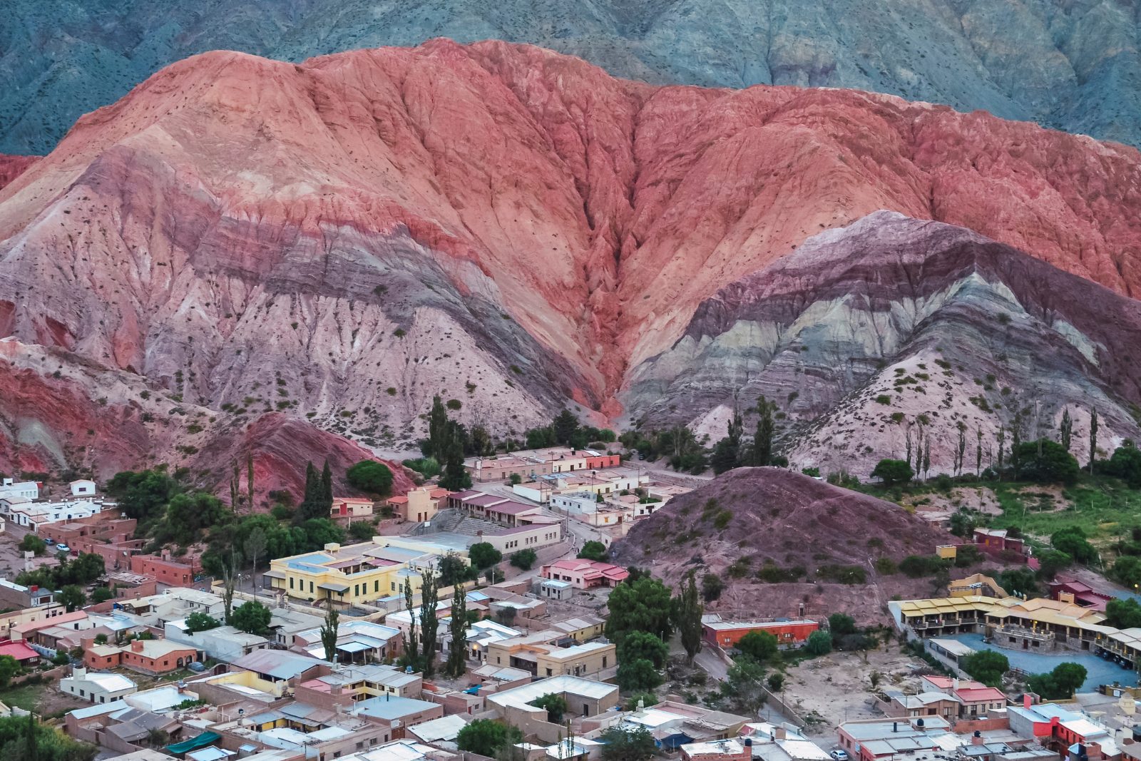 The banded slopes of the Hill of Seven Colors rising directly behind the adobe village of Purmamarca