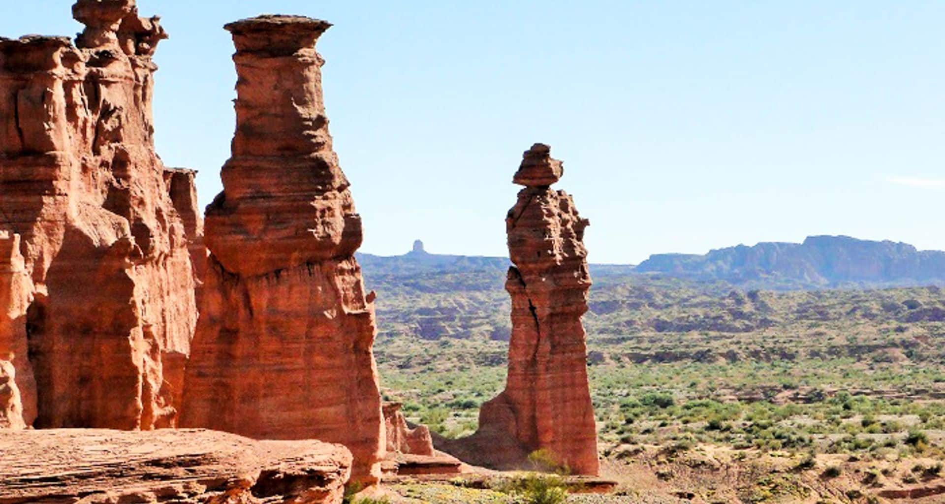 Eroded grey and ochre rock formations standing on the bare floor of Ischigualasto Provincial Park in morning light
