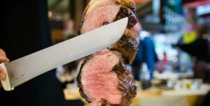 man cutting steak cuts at bbq