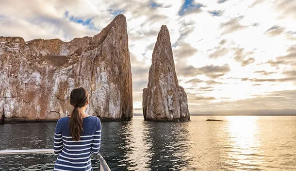 woman looking at kicker rock aboard a cruise ship