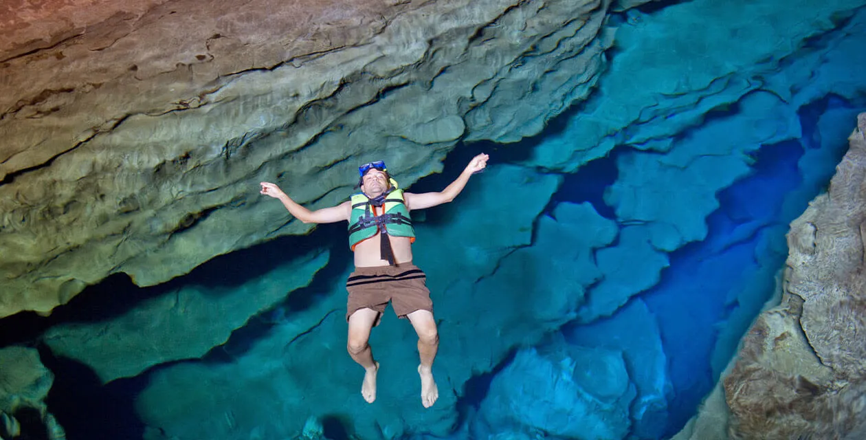man floating in blue cave