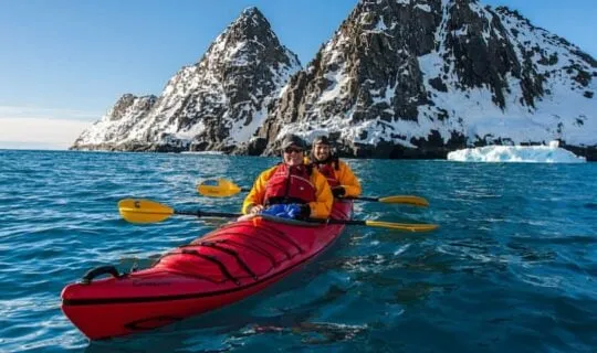 kayakers-in-antarctica-with-glacier-in-background