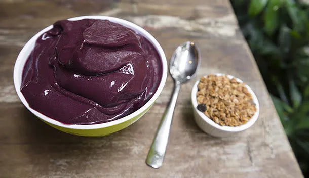 creamy acai bowl with a side of nuts