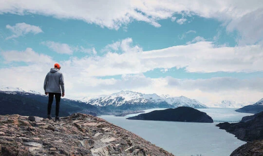 hiker-enjoying-view-of-glacier-and-water