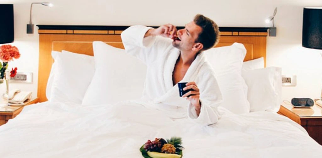 man enjoying room service in bed