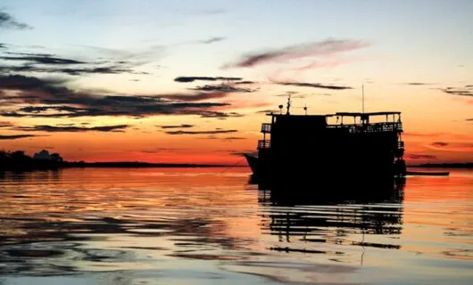 Amazon river cruise ship silhouetted in sunset