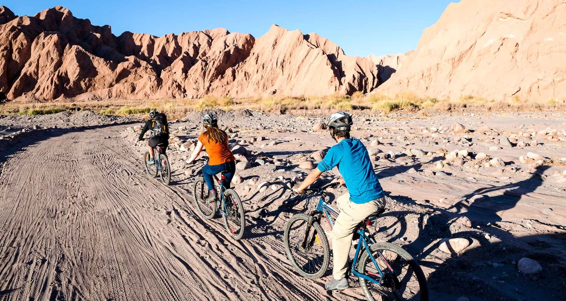Cyclists ride near desert mountains