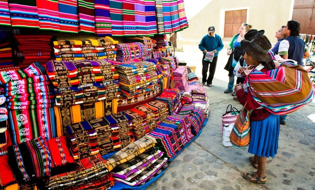 Woman looks at colorful cloth in Bolivia market