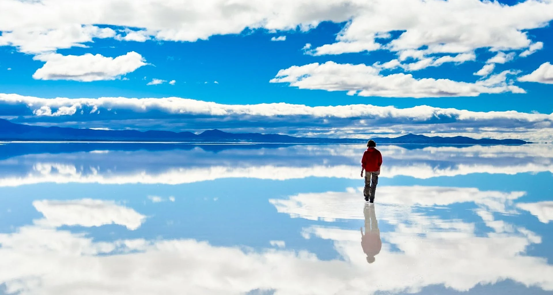 Person walks across reflective salt flats