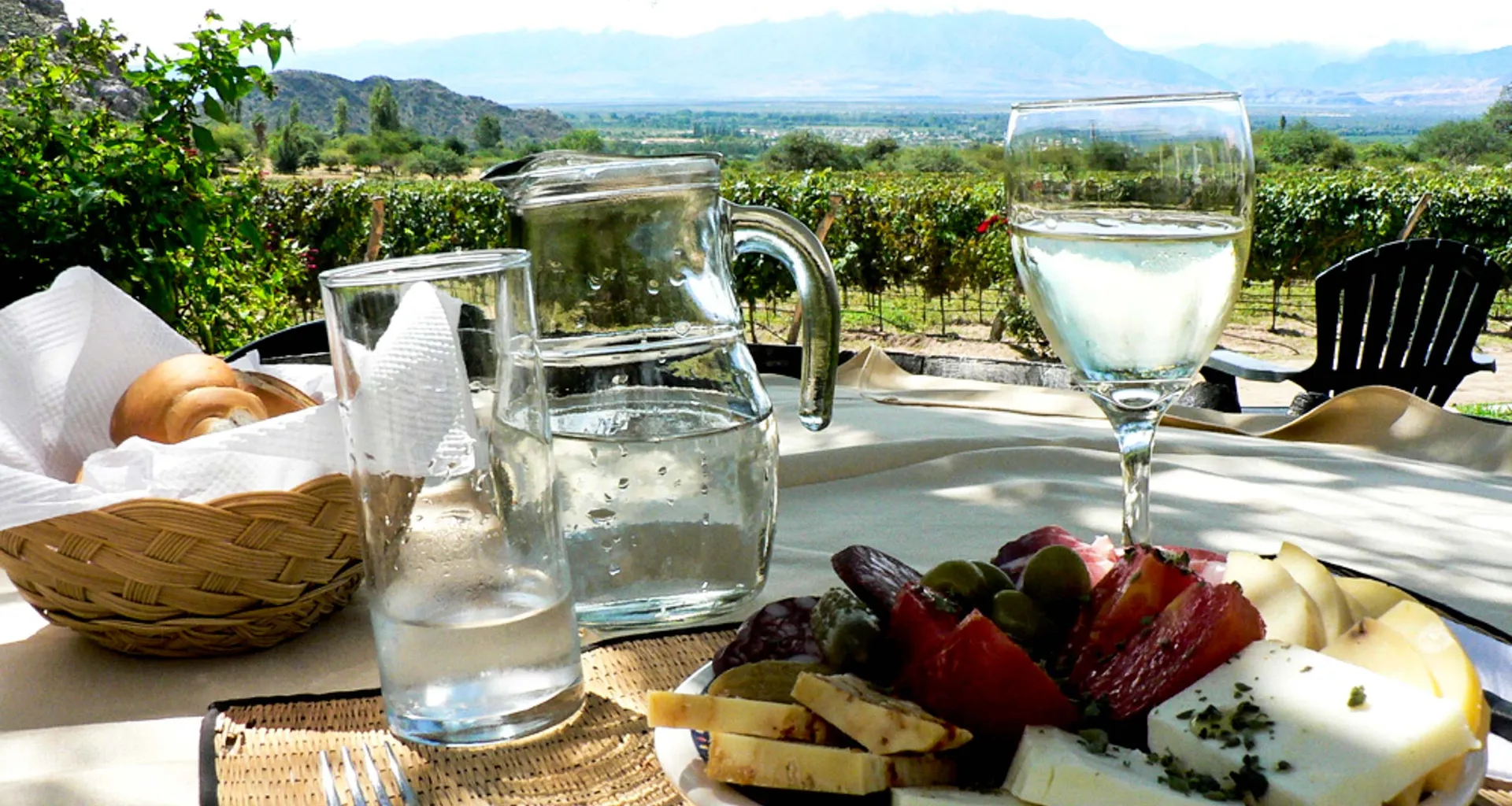 Cheese plate and bread basket laid out in front of South America landscape