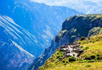 Travelers look at valley from viewing platform overlooking Colca Canyon