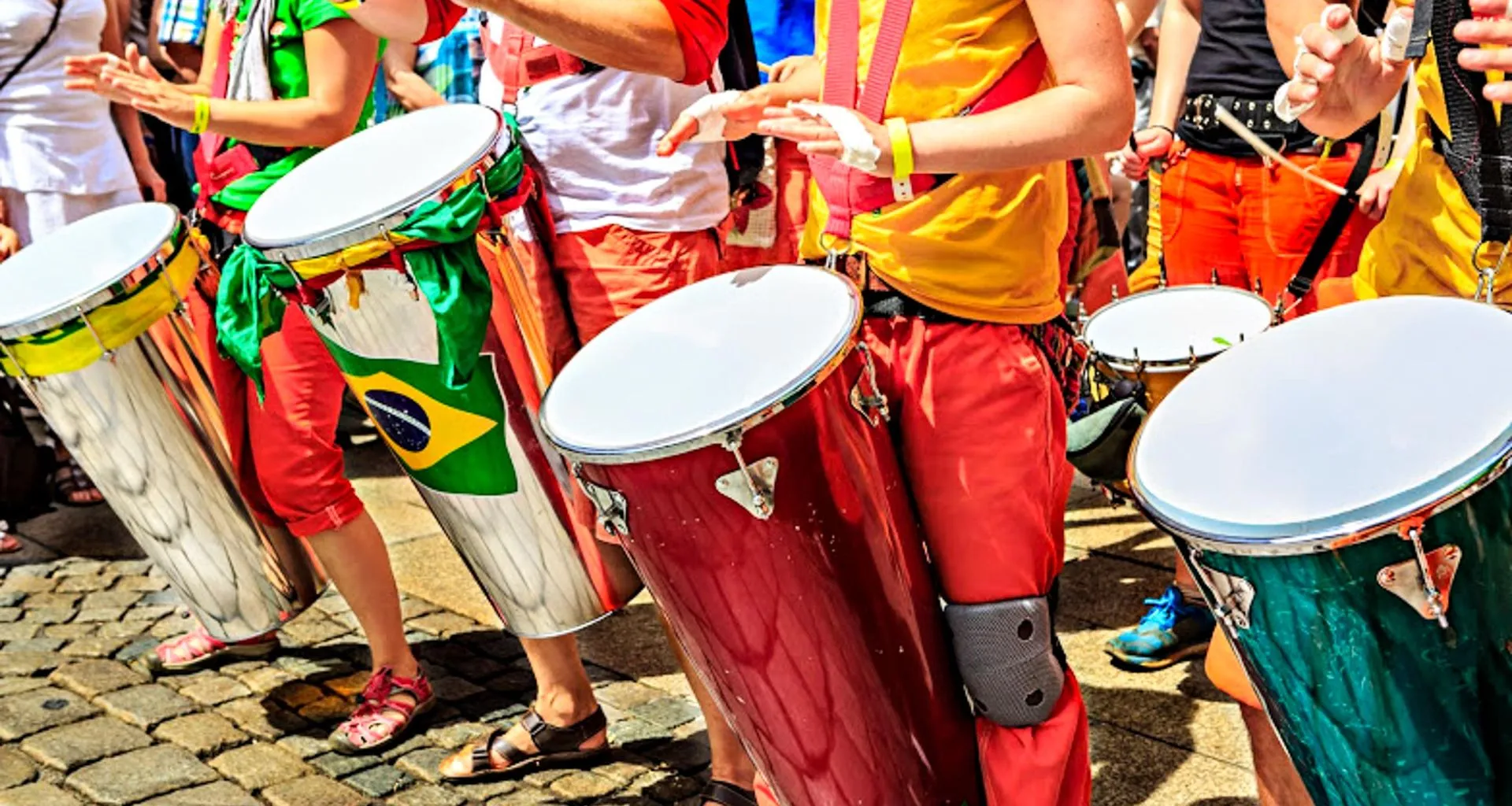 Group of performers play colorful drums