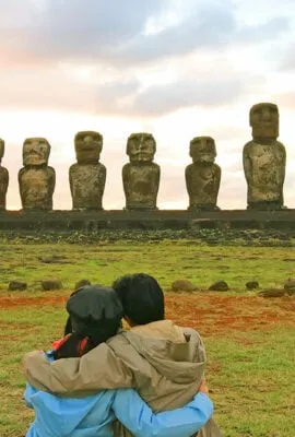 couple looking at the moai statues in easter island