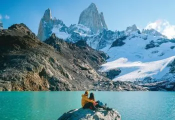 Couple sitting on rock at Torres del Paine National Park Chile