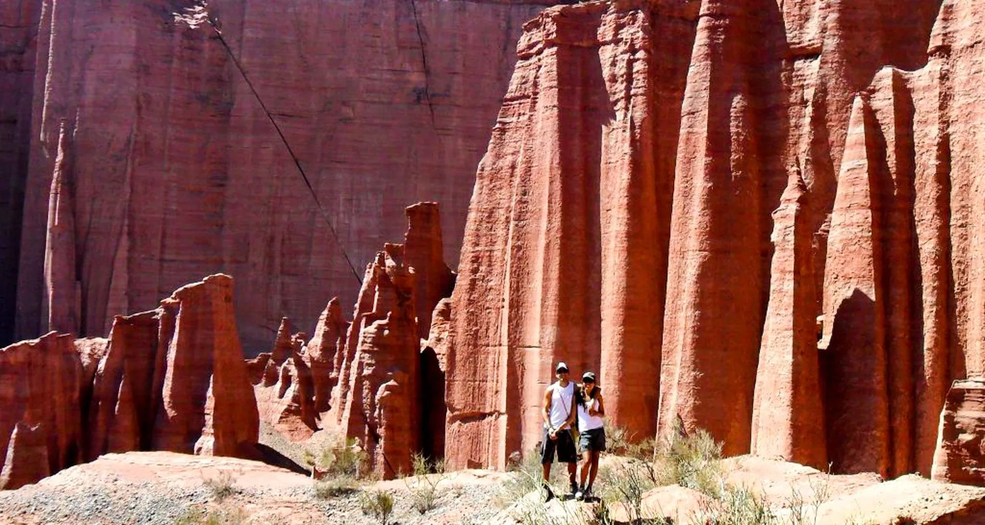 Couple poses in front of large canyon wall