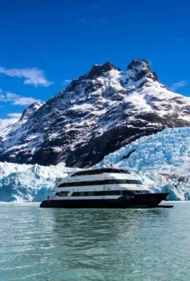 Cruise ship passes by snowy mountain in Chile