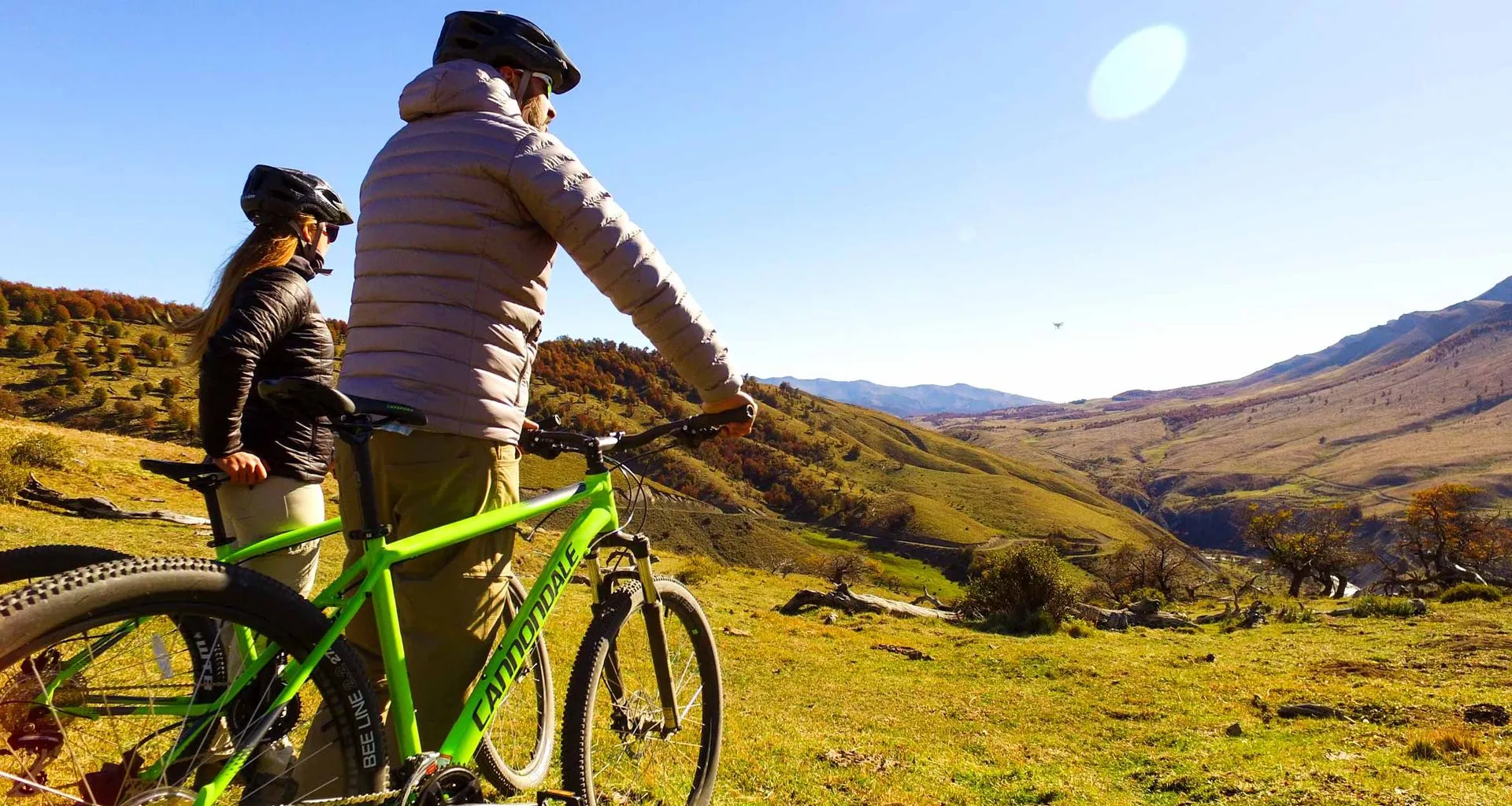 Cyclists rest at top of sunlit valley