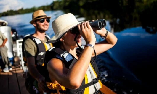 Delfin Cruise travelers use binoculars