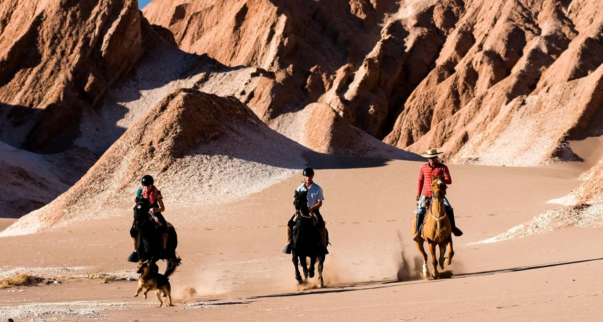 Travelers ride horses through desert