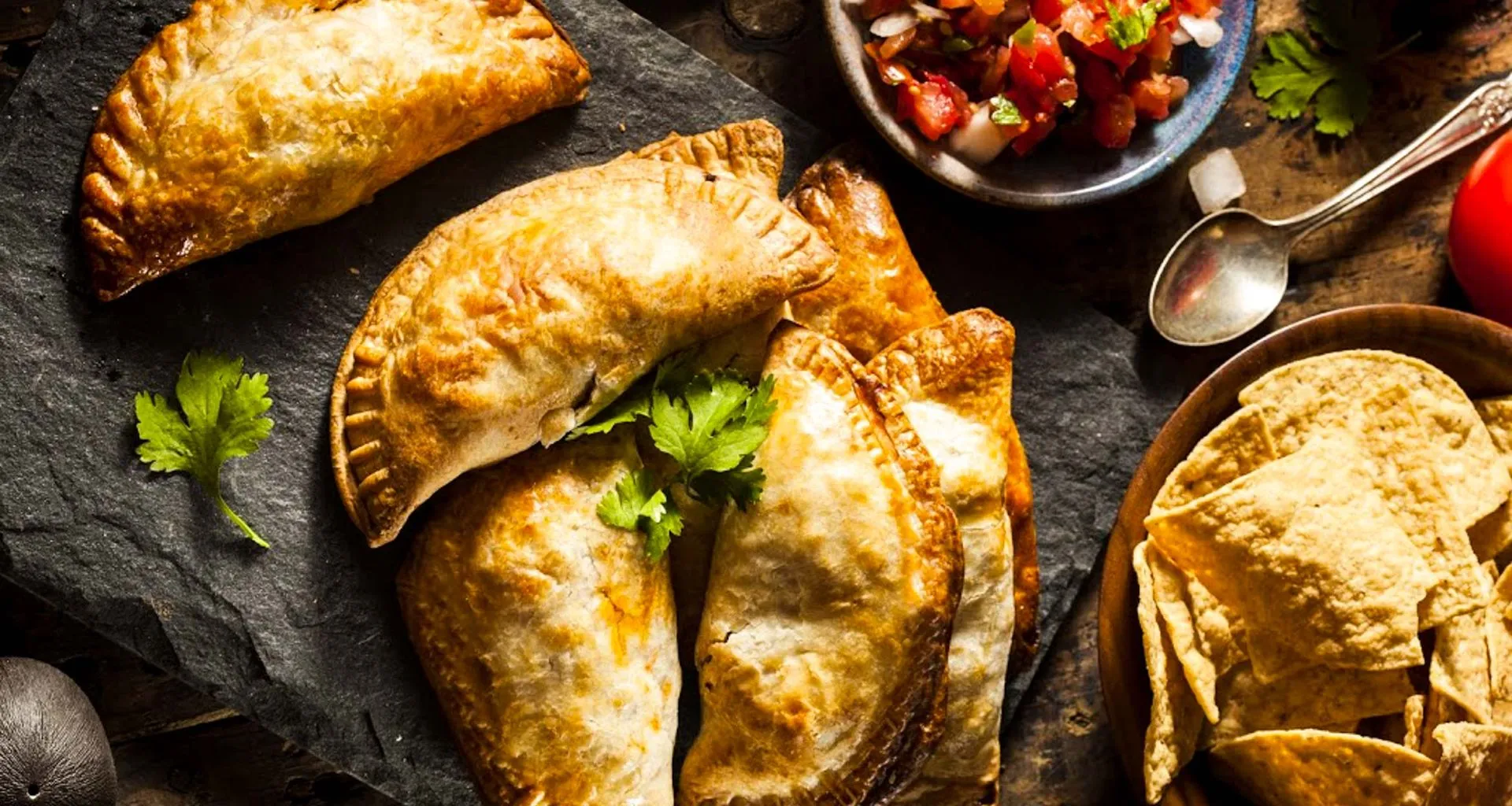 Empanadas laid out on stone platter