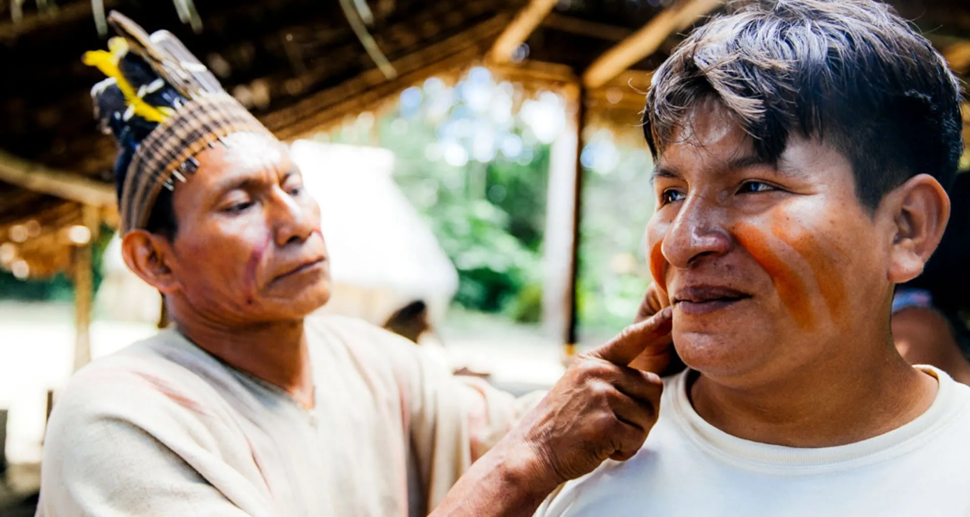 Man applies face paint to another