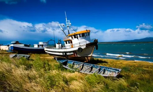 Fishing boat rests on coast near ocean