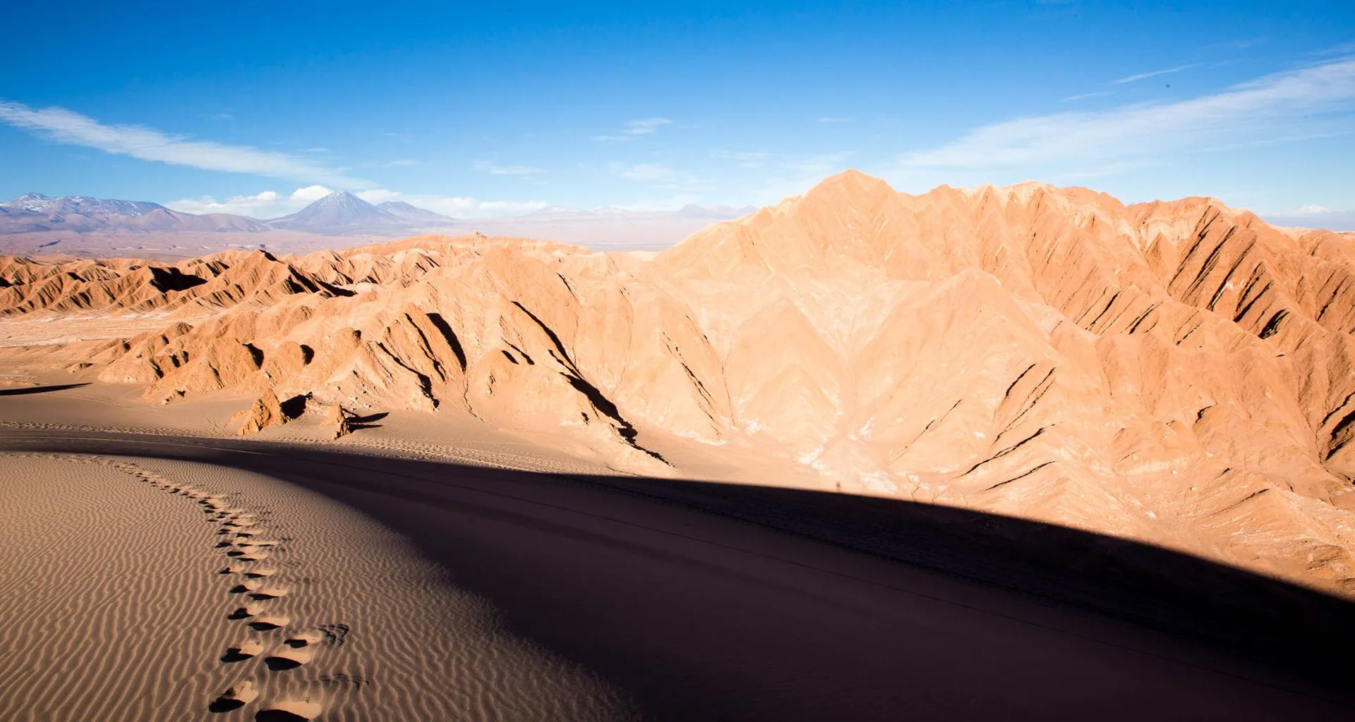 Footsteps in sand near desert mountains