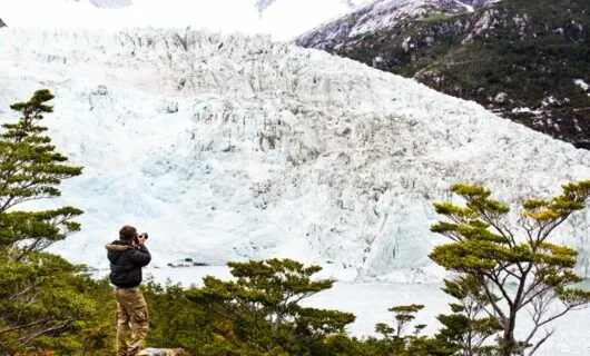 Photographer points camera at large glacier