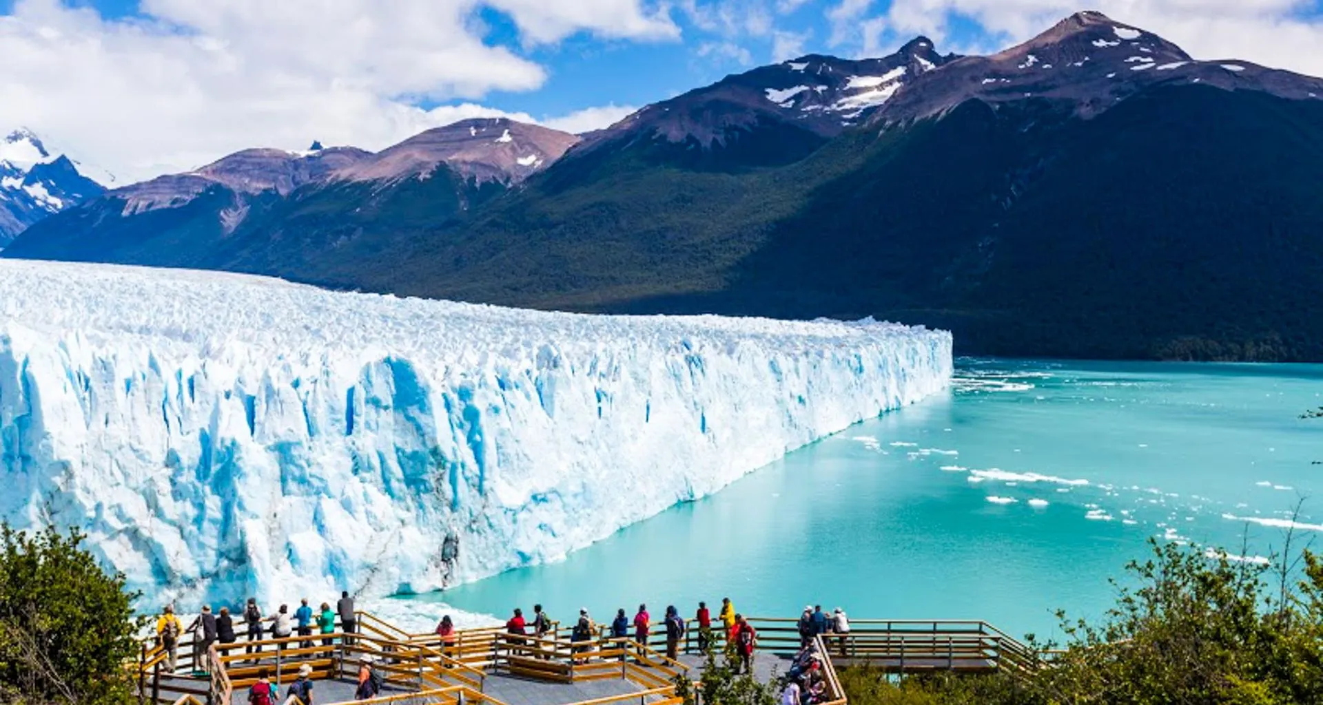 Tourists stand on viewing platform to look at glacier