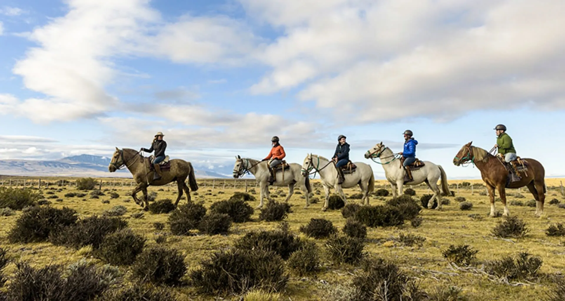 Travelers ride horses in line on plains