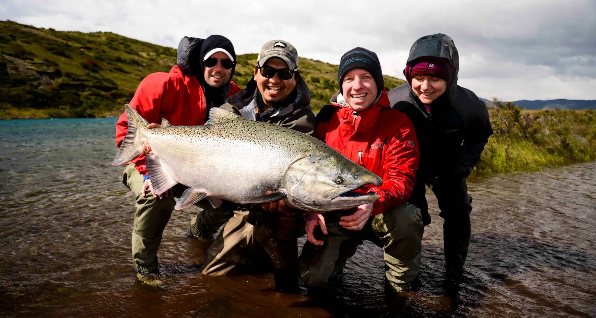 Four people hold large fish