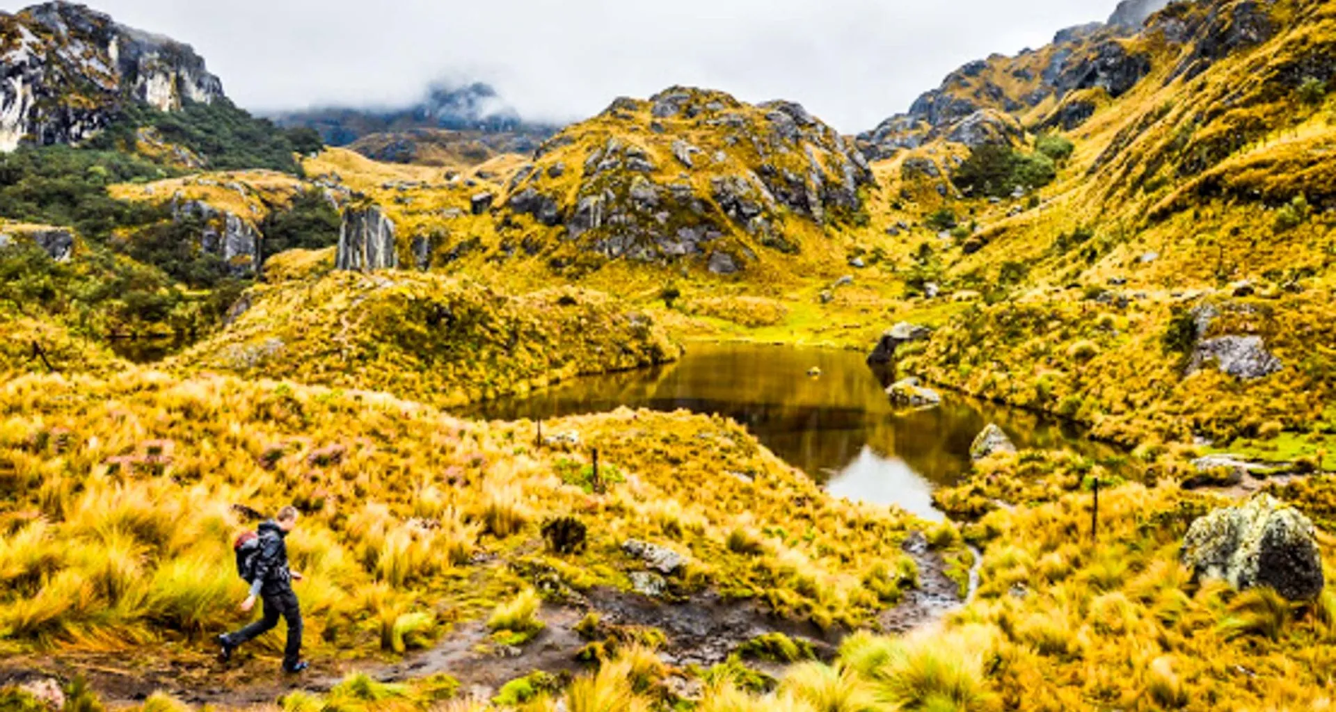 Hiker passes mountain pond