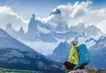 Hiker sitting in front of Patagonia mountain peaks