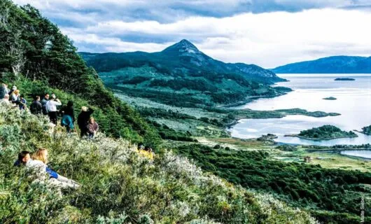 Group of hikers overlook lake in mountain valley