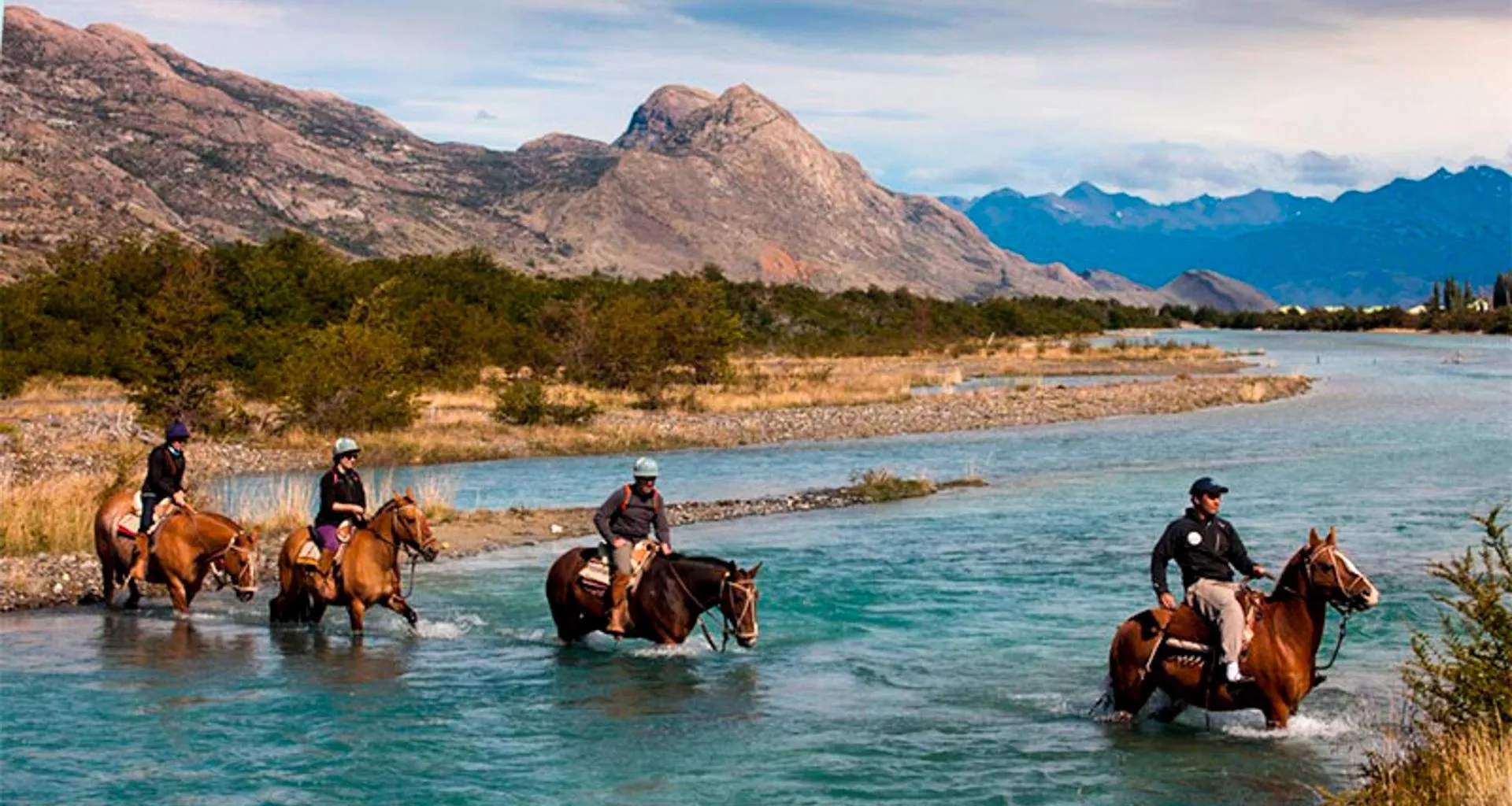 Group of horseback riders cross river