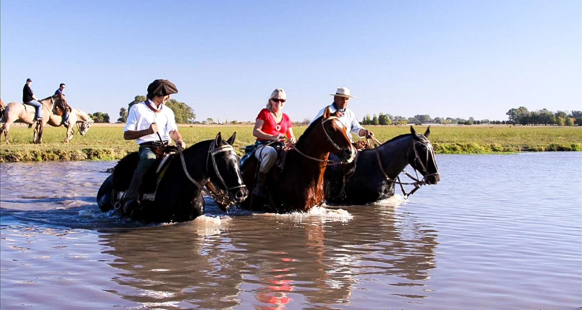Travelers ride horse through river