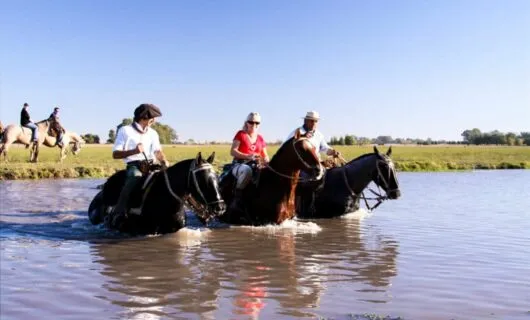 Travelers ride horse through river
