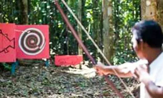 Man does archery in the jungle